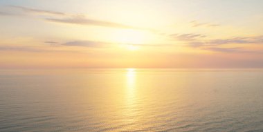 Gün batımında Baltık Denizi. Dramatik gökyüzü, mavi ve pembe parlayan bulutlar, yumuşak altın güneş ışığı, gece yarısı güneşi. Deniz manzarası, bulut manzarası, doğa. Panoramik görünüm