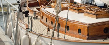 Yeni bir yat limanındaki iskeleye demirlenmiş pahalı bir retro yelkenli (ketch). Tahta meşe güvertesi, zarif detaylar. Ulaşım, denizcilik gemisi, tatiller, turizm, seyahat, yat yarışı, dinlenme