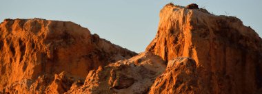 Gün batımında kırmızı kumtaşı kanyonunun panoramik manzarası. Açık mavi gökyüzü. Atmosferik manzara. Seyahat noktaları, dönüm noktaları, doğa, çevre, ekoloji, eko-turizm, yürüyüş, keşif