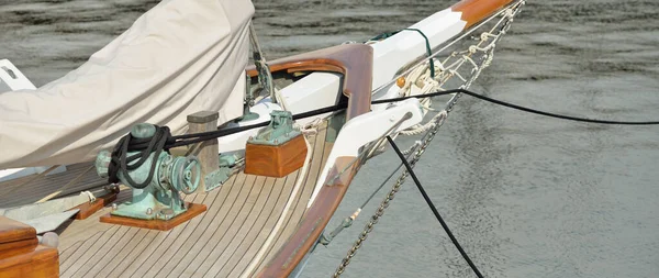 Yeni bir yat limanındaki iskeleye demirlenmiş pahalı bir retro yelkenli (ketch). Tahta meşe güvertesi, zarif detaylar. Ulaşım, denizcilik gemisi, tatiller, turizm, seyahat, yat yarışı, dinlenme