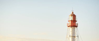 Deniz fenerine karşı açık mavi gün batımı gökyüzü. Hafif ışık, altın saat. Letonya 'nın Pape köyü. Idyllic manzara. İnşaat, sahil güvenlik, yön bulma, umut ve barışın sembolü. Panoramik görünüm, boşluğu kopyala