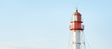 Deniz fenerine karşı açık mavi gün batımı gökyüzü. Hafif ışık, altın saat. Letonya 'nın Pape köyü. Idyllic manzara. İnşaat, sahil güvenlik, yön bulma, umut ve barışın sembolü. Panoramik görünüm, boşluğu kopyala