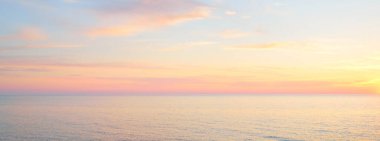 Gün batımında Baltık Denizi. Dramatik gökyüzü, mavi ve pembe parlayan bulutlar, yumuşak altın güneş ışığı, gece yarısı güneşi. Deniz manzarası, bulut manzarası, doğa. Panoramik görünüm