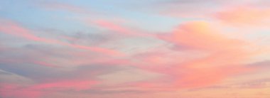 Açık mavi gökyüzü. Pembe ve altın rengi sirrus ve kümülüs bulutları fırtına üstüne, yumuşak güneş ışığı. Dramatik gün batımı bulutları. Meteoroloji, cennet, barış, grafik kaynakları, pitoresk panoramik manzara