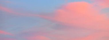 Açık mavi gökyüzü. Pembe ve altın rengi sirrus ve kümülüs bulutları fırtına üstüne, yumuşak güneş ışığı. Dramatik gün batımı bulutları. Meteoroloji, cennet, barış, grafik kaynakları, pitoresk panoramik manzara