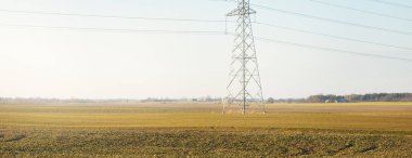 Elektrik hattı açık mavi gökyüzüne karşı, yakın plan. Şehir manzarası kavramı. Enerji, enerji üretimi, özel ekipman, endüstri, çevresel hasar, ekoloji, altyapı, ormanların tahrip