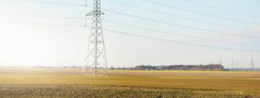 Elektrik hattı açık mavi gökyüzüne karşı, yakın plan. Şehir manzarası kavramı. Enerji, enerji üretimi, özel ekipman, endüstri, çevresel hasar, ekoloji, altyapı, ormanların tahrip