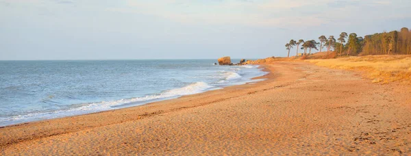 Gün batımında Baltık kıyıları (kum tepeleri). Yumuşak güneş ışığı, berrak gökyüzü, parlayan bulutlar, dalgalar. Idyllic deniz manzarası. Ziemelu Mols, Liepaja, Letonya, Avrupa. Seyahat yerleri, eko-turizm, doğa