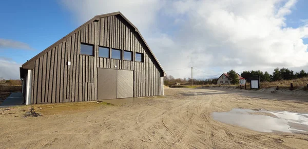 Baltık Denizi 'nin kumlu kıyısındaki küçük bir köyde modern ahşap depo binası. Jurmalciems, Letonya. Mimarlık, endüstri, balıkçılık, tarım ve gıda üretimi, yerel işletme kavramları. Kırsal alan
