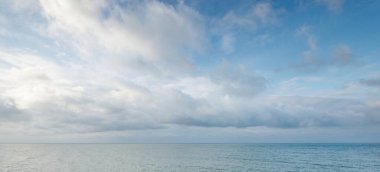 Gün batımında Baltık kıyılarından panoramik hava manzarası. Dramatik bulut manzarası. Kararsız hava, dalgalar ve su sıçramaları. Kış turizmi, küresel ısınma, iklim değişikliği, doğa, ekoloji