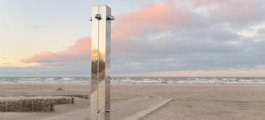 Gün batımında Baltık kıyısı. Eğlence alanı, modern umumi duş. Yumuşak güneş ışığı. Doğa, çevre, yerel seyahat, eko turizm