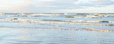 Gün batımında Baltık kıyılarından panoramik manzara. Dramatik bulutlar, parlayan bulutlar, fırtınadan sonra altın güneş ışığı. Doğa, çevre, iklim değişikliği, kararsız hava