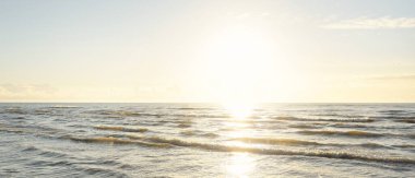 Kumlu bir sahilden (kum tepeleri) Baltık denizinin panoramik görüntüsü. Parlayan bulutlarla, dalgalarla ve su sıçramalarıyla berrak bir gökyüzü. Idyllic deniz manzarası. Sıcak kış havası, iklim değişikliği, doğa