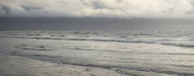 Fırtınadan sonra Baltık Denizi. Yumuşak günbatımı ışığı, çarpıcı parlayan bulutlar. Deniz manzarası, bulutlar, doğa. Panoramik manzara. Ekoloji, iklim değişikliği, hava durumu