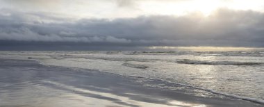 Fırtınadan sonra Baltık Denizi. Yumuşak günbatımı ışığı, çarpıcı parlayan bulutlar. Deniz manzarası, bulutlar, doğa. Panoramik manzara. Ekoloji, iklim değişikliği, hava durumu
