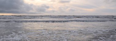 Fırtınadan sonra Baltık Denizi. Yumuşak günbatımı ışığı, çarpıcı parlayan bulutlar. Deniz manzarası, bulutlar, doğa. Sudaki yansımalar. Panoramik manzara. Ekoloji, iklim değişikliği, hava durumu