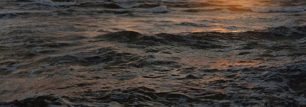 日没の海の海岸 水面の質感 嵐の波 抽象的な背景 濃い赤 柔らかい日差し 黄金の時間 静けさのテーマ — ストック写真