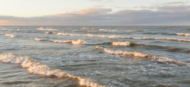 Eski rıhtımın manzarası. Dalgakıranlar yakın çekim. Dramatik gün batımı gökyüzü, altın güneş ışığı. Deniz manzarası, bulut manzarası. Baltık Denizi. Bahar. Turizm, dönüm noktası, navigasyon