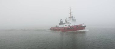 Kalın bir siste römorkör. Baltık Denizi. Kış deniz manzarası. Nakliye, deniz taşımacılığı, lojistik, sanayi, ticaret, ekonomi