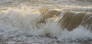 Fırtınadan sonra Baltık kıyıları. Gün batımı, yumuşak güneş ışığı. Su yüzeyi dokusu, çarpan dalgalar, sıçramalar, köpük. Resimli panoramik manzara. Idyllic deniz manzarası. Doğa, çevre, ekoloji temaları