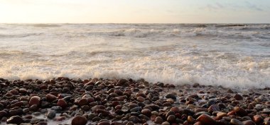 Gün batımında Baltık kıyılarından panoramik manzara. Dramatik bulutlar, parlayan bulutlar, fırtınadan sonra altın güneş ışığı. Doğa, çevre, iklim değişikliği, kararsız hava