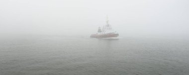 Kalın bir siste römorkör. Baltık Denizi. Kış deniz manzarası. Nakliye, deniz taşımacılığı, lojistik, sanayi, ticaret, ekonomi