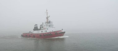 Kalın bir siste römorkör. Baltık Denizi. Kış deniz manzarası. Nakliye, deniz taşımacılığı, lojistik, sanayi, ticaret, ekonomi