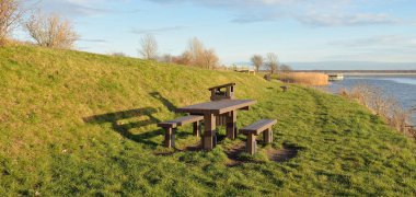 Modern dinlenme alanı, orman parkı, göl. Tahta banklar, masalar. Kamp alanı. Yumuşak güneş ışığı, açık gökyüzü. Baharın başında. Idyllic manzara. Doğa, çevre, ekoloji, eko-turizm, tatiller, hafta sonu