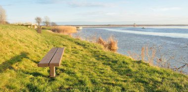 Modern dinlenme alanı, orman parkı, göl. Tahta banklar, masalar. Kamp alanı. Yumuşak güneş ışığı, açık gökyüzü. Baharın başında. Idyllic manzara. Doğa, çevre, ekoloji, eko-turizm, tatiller, hafta sonu