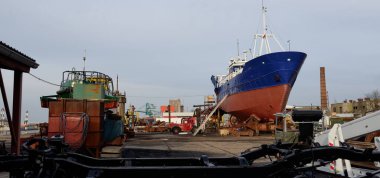 Karada duran eski gemi. Liman, tersane. Sanayi bölgesi. Ulaşım, onarım, servis. Havalandırma, Letonya, Baltık Denizi