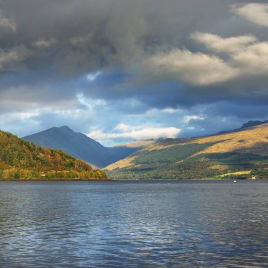 Bulutlu bir günde Loch Fyne yakınlarındaki sahil, orman ve tepelerin manzarası. Inveraray, Inner Hebrides, Argyll ve Bute, İskoçya, İngiltere