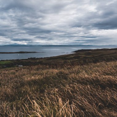 Jura adasının kıyıları, dağları ve vadilerinin panoramik hava manzarası. Bulutlu mavi gökyüzü. Fırtınalı hava. Paps of Jura, Inner Hebrides, İskoçya, İngiltere. Seyahat yerleri, turizm, ulusal simgeler
