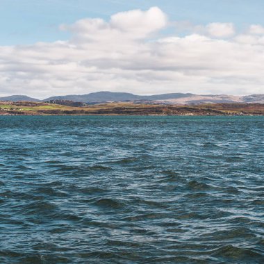 Yat manzaralı Jura adasının batı kıyısındaki kayalık kıyılara (uçurumlara) yelken açmak. Parlak bulutlu dramatik günbatımı gökyüzü. Inner Hebrides, İskoçya, İngiltere. Seyahat yerleri, işaretler