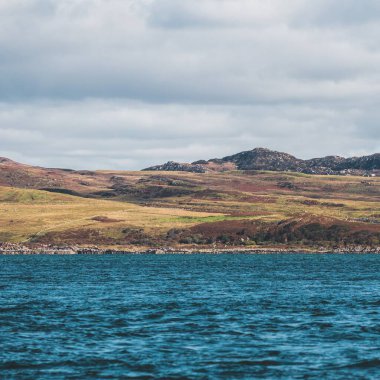 Yat manzaralı Jura adasının batı kıyısındaki kayalık kıyılara (uçurumlara) yelken açmak. Parlak bulutlu dramatik günbatımı gökyüzü. Inner Hebrides, İskoçya, İngiltere. Seyahat yerleri, işaretler