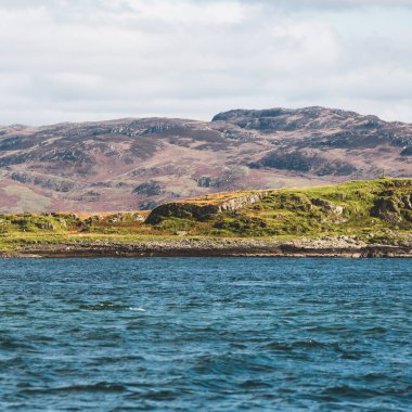 Yat manzaralı Jura adasının batı kıyısındaki kayalık kıyılara (uçurumlara) yelken açmak. Parlak bulutlu dramatik günbatımı gökyüzü. Inner Hebrides, İskoçya, İngiltere. Seyahat yerleri, işaretler