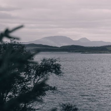 Crinan yakınlarındaki kayalık kıyıların, uçurumların, tepelerin, dağ tepelerinin ve ormanlık alanların panoramik hava manzarası. Argyll ve Bute, İskoçya, İngiltere. Dramatik bulut manzarası. Seyahat yerleri, turizm teması