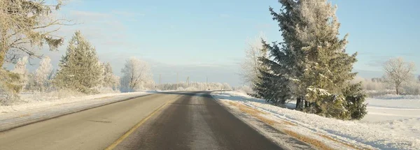 Karla kaplı orman ve kırsal alanda boş otoyol (asfalt yol). Kar sürükleniyor. Avrupa. Doğa, Noel tatilleri, uzak yerler, kış lastikleri, tehlikeli sürüş konsepti