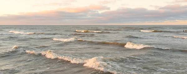 Gün batımında Baltık kıyılarından panoramik manzara. Dramatik bulutlar, parlayan bulutlar, fırtınadan sonra altın güneş ışığı. Doğa, çevre, iklim değişikliği, kararsız hava
