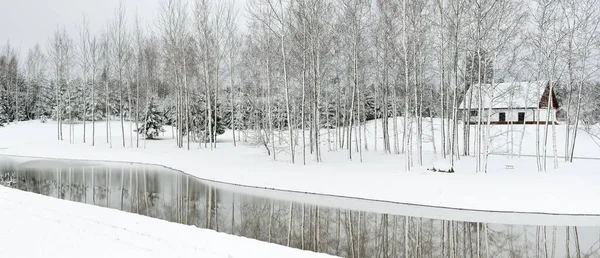 在多云的冬日里 森林河流和孤寂的现代传统住宅 年轻的云杉和桦树 田园诗般的乡村风景 圣诞假期 生态度假胜地 偏远地区 — 图库照片