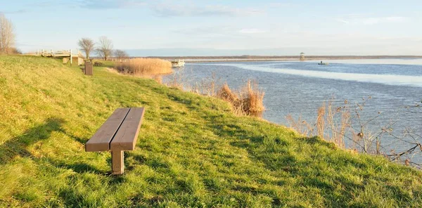 Modern dinlenme alanı, orman parkı, göl. Tahta banklar, masalar. Kamp alanı. Yumuşak güneş ışığı, açık gökyüzü. Baharın başında. Idyllic manzara. Doğa, çevre, ekoloji, eko-turizm, tatiller, hafta sonu
