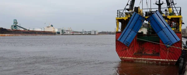 Balıkçı teknesi (trol teknesi) kargo limanına demir attı. Baltık Denizi, Ventspils, Letonya. Ulaşım, geleneksel zanaat, lojistik, endüstri, özel ekipman