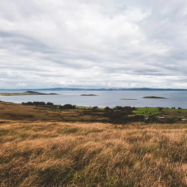 Jura adasının kıyıları, dağları ve vadilerinin panoramik hava manzarası. Bulutlu mavi gökyüzü. Fırtınalı hava. Paps of Jura, Inner Hebrides, İskoçya, İngiltere. Seyahat yerleri, turizm, ulusal simgeler