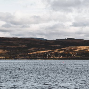 Dramatik gökyüzü altında Tarbert 'in kayalık kıyılarının panoramik manzarası. İskoçya, İngiltere. Seyahat yerleri, ulusal dönüm noktası, eğlence, eko turizm, tatiller, macera, keşif
