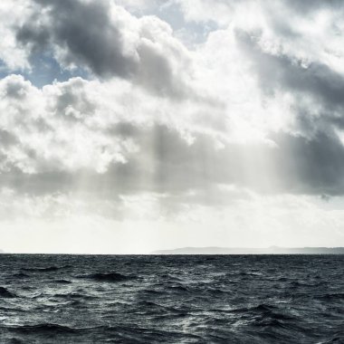 Sudan kayalık nehir kıyılarının panoramik görüntüsü. Arka planda ağaçlar, tepeler ve dağlar var. Bulutlu mavi gökyüzü. Gare Loch, Clyde Firth, İskoçya, İngiltere