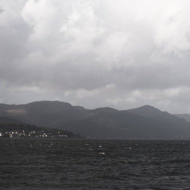 Clyde Nehri 'nin kayalık kıyısı, yelkenli tekneden panoramik manzara. Fırtınadan sonra dramatik bir gökyüzü. İskoçya, İngiltere. Seyahat yerleri, eko turizm, tatiller, saf doğa. Atmosferik manzara