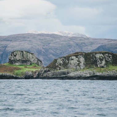 Yat manzaralı Jura adasının batı kıyısındaki kayalık kıyılara (uçurumlara) yelken açmak. Fırtınadan sonra dramatik bulutlar. Inner Hebrides, İskoçya, İngiltere. Atmosferik manzara