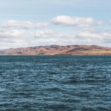 Yat manzaralı Jura adasının batı kıyısındaki kayalık kıyılara (uçurumlara) yelken açmak. Parlak bulutlu dramatik günbatımı gökyüzü. Inner Hebrides, İskoçya, İngiltere. Seyahat yerleri, işaretler