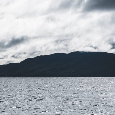 Dramatik gökyüzü altında Tarbert 'in kayalık kıyılarının panoramik manzarası. İskoçya, İngiltere. Seyahat yerleri, ulusal dönüm noktası, eğlence, eko turizm, tatiller, macera, keşif