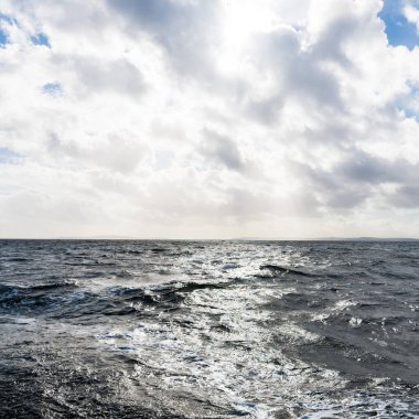 Ormanlık, tepeler ve dağlar Firth of Clyde nehrinin yanında, yelkenli bir teknenin manzarası. Fırtınadan sonra dramatik bir gökyüzü. İskoçya, İngiltere. Seyahat yerleri, eko turizm, saf doğa. Atmosferik manzara