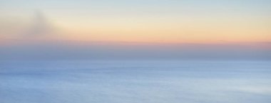 Kalın beyaz sis bulutları içinde nefes kesici panoramik deniz manzarası. Parlak gökyüzü, gece yarısı güneşi, alacakaranlık. Resimli bir manzara var. Rüya gibi bir manzara. Saf doğa, çevre, ekoloji, turizm